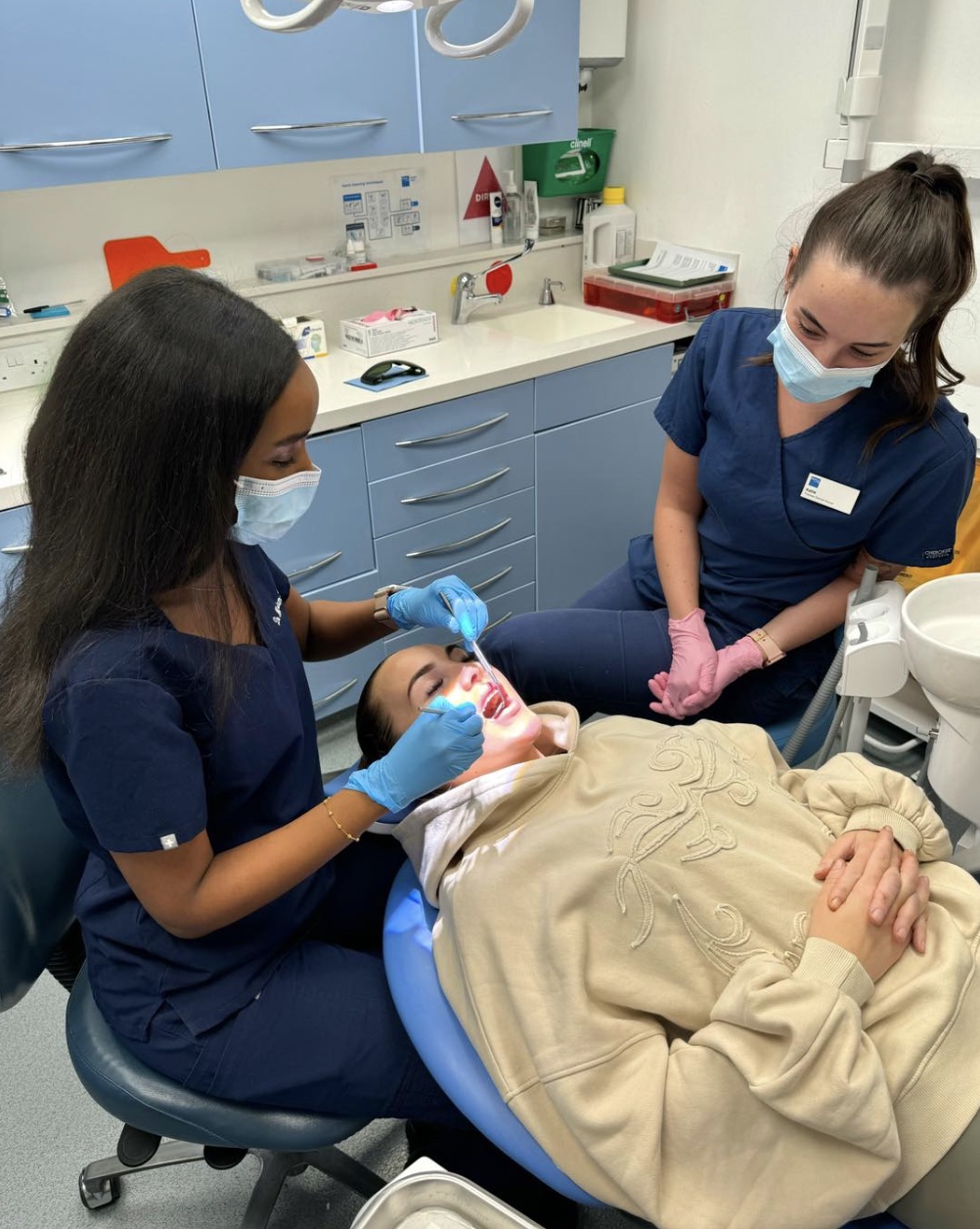 Dr Mariam treating a patient with her dental nurse beside her